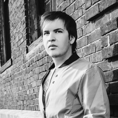 Image of young, dark-haired man looking intent in front of a brick wall. Vaughn Navarro - AI Specialist, NAVARRO CREATIVE GROUP - Digital Marketing Professionals in Nashville