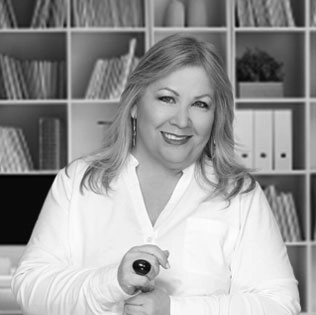 Image of light-haired woman in white shirt smiling in front of a bookshelf - Wendy Navarro, CEO, NAVARRO CREATIVE GROUP - Digital Marketing Professionals in Nashville